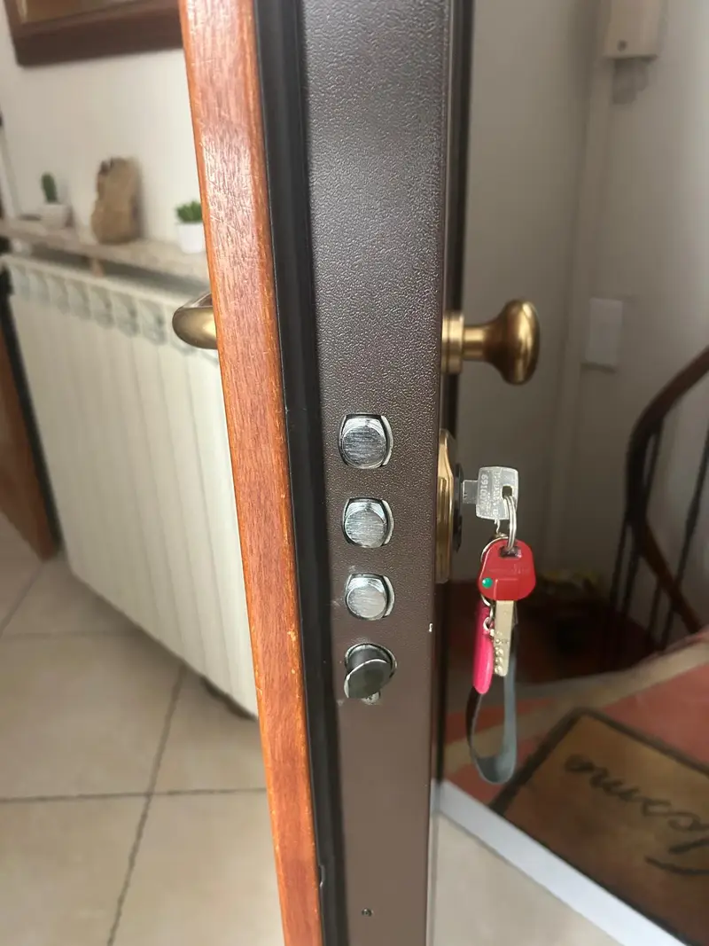 Porte blindée multipoints ouverte, pênes sortis et clé sur le cylindre